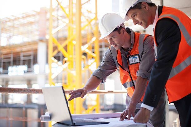 Profesionales revisando un proyecto en obra